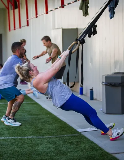 CFDHFMURPH-210 Woman on pulls with a personal trainer duirng CrossFit DHF training.