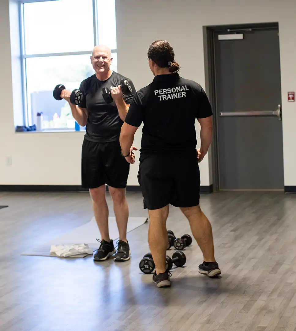 Senior man working with a personal trainer.