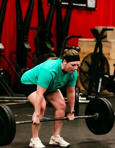 FNL-419 Woman gets ready to lift weights duirng CrossFit DHF training.