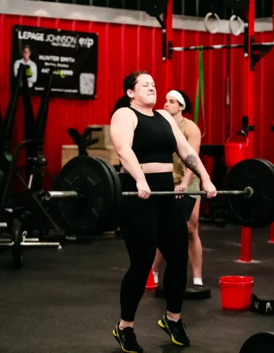 FNL-428 Woman puts effort into lifting weights duirng CrossFit DHF training.