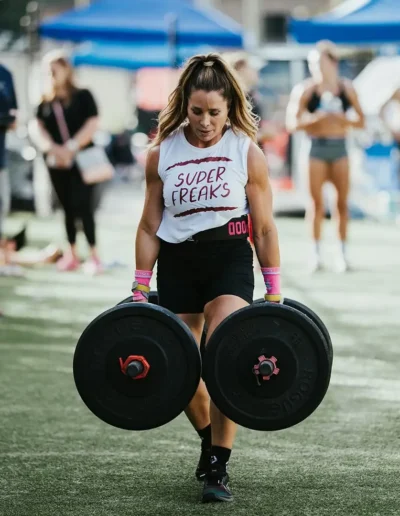 IMG_6424 Fit woman walks while carrying large weights duirng CrossFit DHF training.