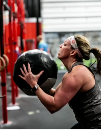IMG_6425 Muscular woman squats with exercise ball duirng CrossFit DHF training.