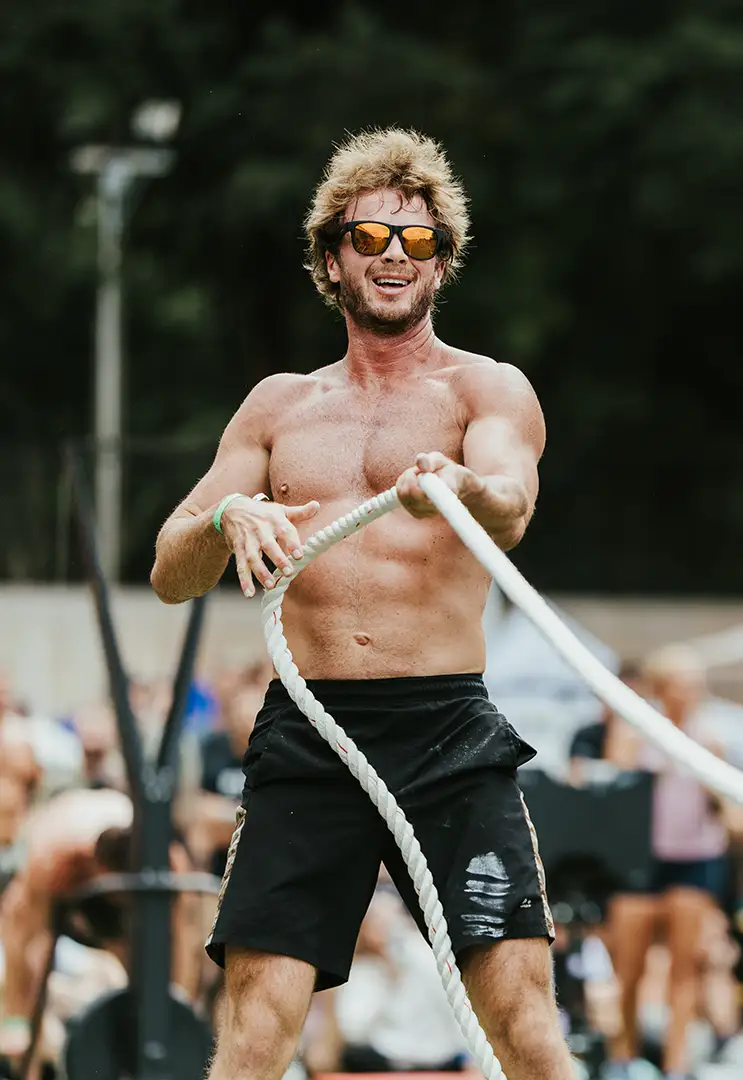 A muscular and fit man pulling on a rope during a Fit Fest competition.
