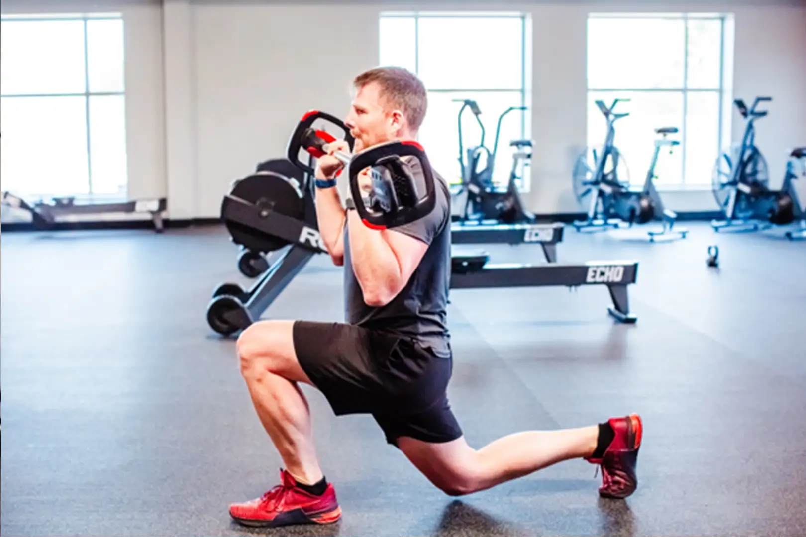 dhf-evolution4 Man doing squats with a barbell.